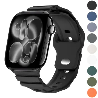 Black Intrepid Apple Watch band in matte rubber with perforated adjustment holes, raised ridged accents, and black connectors, shown installed in an angled product view.